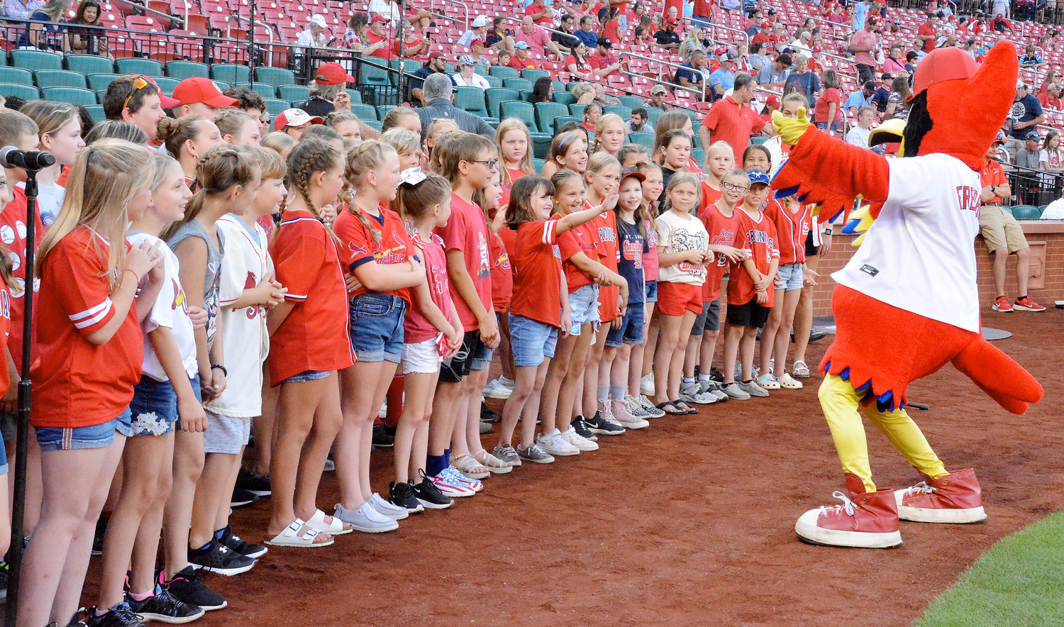 Owensville Elementary School (OES) and Gerald Elementary School (GES) choir students watch St. Louis Cardinals mascot Fredbird entertain them prior to their singing.